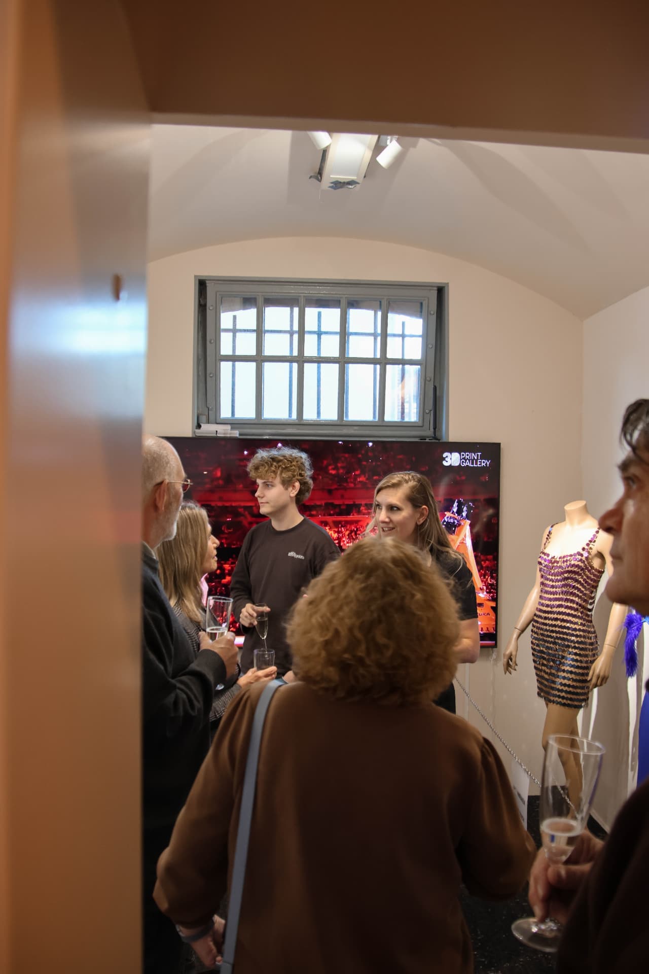 Visitors sharing a drink beside the 3D-printed fashion exhibition at the 3D-Print Gallery in Haarlem